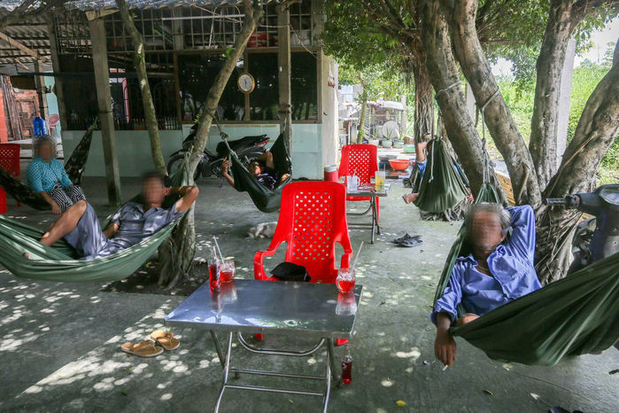 Les gens prennent une boisson ou font la sieste dans un hamac